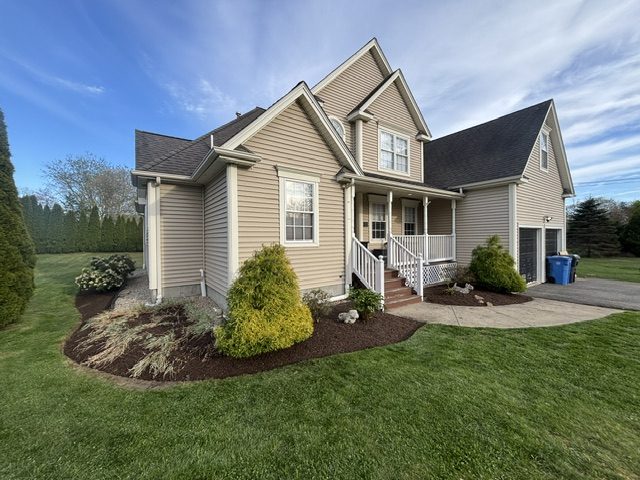 Home with freshly mulched foundation beds and neatly trimmed shrubs along the front walkway